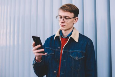 Genç hipster blogger posta denetleme ve takipçileri smartphone ücretsiz 4 g internet bağlantısı kullanma sosyal ağ ile mesajlaşma. Genç online telefon ayakta kentsel ortamda sohbet