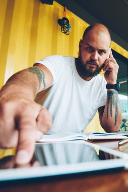 Başlangıç yazılım güncelleştirmesi için dijital tablet telefon ve basın güvenlik kodu konuşurken ciddi sakallı adam portresi, bin yıllık adam akıllı telefon konuşmayı unlock için ekrandaki parmak koymak