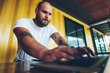 Dizüstü bilgisayar, netbook yazarak kod ofiste vakit yeni uygulama yükleme ciddi bin yıllık erkek programcı üzerinde video oyun oynarken konsantre endişeli beyaz hipster adam