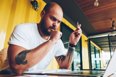 Konsantre erkek öğrenci el eğitim webinar online kurslar yoluyla bilgi almak izlerken kalem ile akıllı ciddi adam ağlardan bilgisi çözümlenirken hazırlamak yayın yapmak için