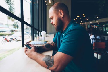 Sosyal ağlar içerik ara kafeterya, yaratıcı erkek bolgger takipçileri ile bir paylaşım cep telefonu ve wifi kullanarak multimedya sohbet ile smartphone ile yeni güncelleştirmeleri denetlemeyi genç hipster adam