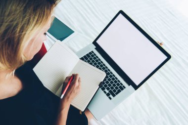 Evdeki netbook üzerinden online eğitim kurslarında çalışan kadın yazma bilgilerinin en üst görünümü, bilgisayar kullanan kadın blogcu, web sitesi için yazı hazırlıyor