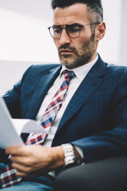 Dalgın Olgun ofis çalışanı yazılı kağıt belgeler üzerinde hesap bilgilerini analiz takım elbiseli. İşadamı 50 yaşında kurumsal şirkette çalışan mali raporları okuma konsantre