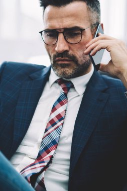 İş ortağı ile smartphone üzerinde konuşmak ve strateji telefon görüşmesi sırasında tartışırken formal giyim emin olgun girişimci. Telefon aygıtı çalışma sorunları çözme gurur CEO'su deneyimli