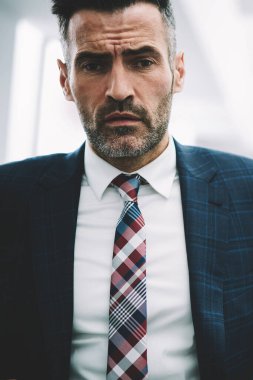 Yarım uzunluk portre emin gurur CEO 50 yaşında kameraya bakıyor. Başarılı olgun işadamı formal giyim ofis iç kapalı duran giyinmiş. Finans şirketinin erkek sahibi