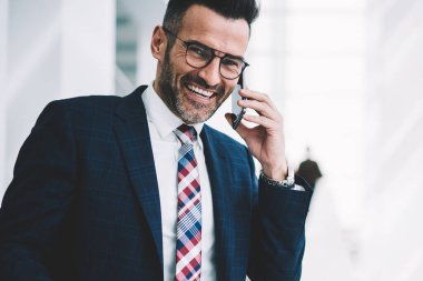 Başarılı bir iş adamı portresi smartphone aygıt üzerinde arama ve telefon konuşma ayakta Office Kurumsal şirketin kopyalama alanı alanı yakınındaki sırasında gülüyor formal giyim giyinmiş