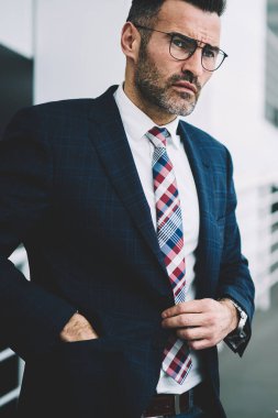 Düz seyir formal giyim giyinmiş düşünceli emin orta yaşlı girişimci. Cep ayakta kendi kurumsal şirket ofisinde ele sahip şık elbiseli ciddi başarılı iş adamı