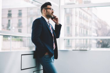 Başarılı olgun girişimci ciddi iş konuşmayı Smartphone'da formal giyim giymiş. Kendine güvenen gurur CEO'su 50 yaşında modern telefon ayakta Office arama durulması