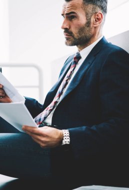 Girişimci 50 yaşındaki formal giyim ofis iç oturan kağıt mali belgelerin incelenmesi eski durulması. Muhasebe raporları holding ve düz seyir düşünceli olgun tüccar