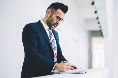Dalgın olgun girişimci formal giyim ofis iç çalışma mali belgelerin incelenmesi giymiş. Bilgi okumada ve muhasebe raporları imzalama emin gurur CEO'su orta yaşları