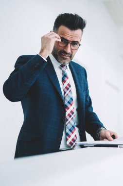 Orta yaşlı işadamı yarım uzunluk portre formal giyim ayakta finans şirketi office Ardiles belgelerle giyinmiş. Kameraya bakarak formal giyim başarılı olgun girişimci