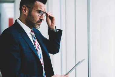 Düşünceli emin gurur CEO'su görünümünü 50 yıl eski pencereden dışarı bakıyor finansal haber tablet ile Web sitesi güncelleştirilirken bağlı 4 g için yan Internet. Dokunmatik yüzey ile başarılı bir tüccar durulması