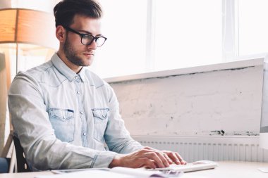 Ciddi bir erkek yazılım geliştirici klavye programı modern bilgisayarda ofis masasında oturuyor, beyaz yetenekli bir adam PC bilgisayarıyla birlikte çalışıyor. Dijital pazarlama okulları