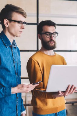 Bir grup yeniyetme genç adam dizüstü bilgisayarla dosya indirirken 4G internete göz atıyorlar, Kafkasyalılar modern ofiste işbirliği yapıyorlar ve netbook bilgisayarında çalışmak için uygulama yüklüyorlar.