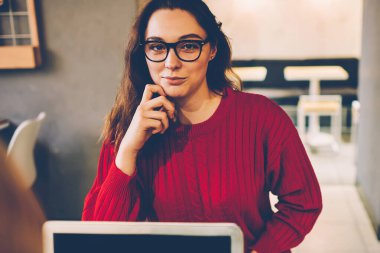 Gözlüklü güzel bir genç kadının portresi dizüstü bilgisayarın yanında oturuyor. Serbest çalışıyor, üniversite sınavlarını öğreniyor. Kampüsteki teknolojiyi kullanarak kameraya bakıyor.