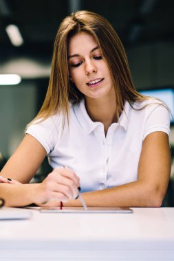 Modern teknoloji ile Üniversite Kütüphanesi, yetenekli genç kadın tasarımcı makign eskiz kalemi kullanarak taşınabilir PC içinde elektronik kalem touchpad üzerinde çizim kullanarak yaratıcı kadın sanatçı konsantre