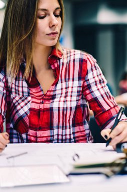 Mimari Proje alanı ile Kırtasiye, dalgın kız öğrenci çizim grafik taslak oluşturma tasarım üzerinde konsantre ödev için coworking oturan için planı hazırlanması ciddi genç kadın