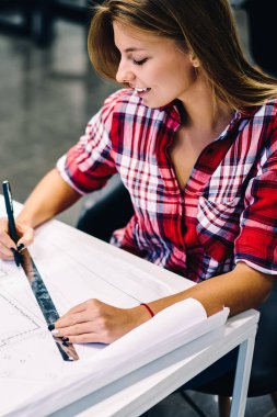 Gülümseyen kız öğrencinin Üniversitede kampüs, mutlu kadın mimar inşaat hazırlanması planı üzerinde çalışmanın tamamlanması ile memnun ileti örneği ile kroki çizim yaratıcı görev yapmanın tadını çıkarıyor