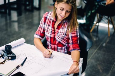Kız öğrencinin ders planı accountings ile büyük iş memnun kontrol gülümseyerek olumlu yetenekli kadın mimar proje üzerinde çalışma süreci zevk kağıt üzerine çizim inşaat kroki