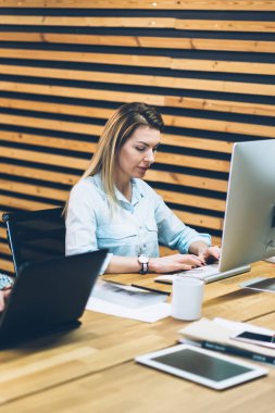 Dalgın erkek ve kadın ofis çalışanları metni klavye kullanarak Internet Web siteleri hakkında bilgi aramak için modern bilgisayarlara bağlı. Grafik tasarımlarıyla ofis iç dijital dizüstü bilgisayarlar çalışma