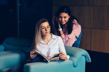 Pozitif hipster kızlar çekici kapalı vakit ise iyi bir atmosferde iletişim şık elbise giymiş. Dergi makalelerini görüntüleyerek rekreasyon zevk çekici en iyi arkadaşlar