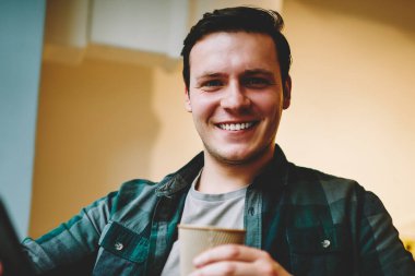 Neşeli genç adam ağ telefon, müreffeh erkek blogger takipçileri smartphone üzerinden sohbet için iyi Wi-Fi bağlantısı ile kafeteryada oturan eğlence üzerinde favori kahve zevk