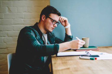 Dalgın hipster adam notings ve muayene, zeki genç erkek kişi kafe proje görevleri tamamlamak için liste yapmak için kontrol için ders kitapları bulunan bilgileri öğrenme alanı coworking eğitim