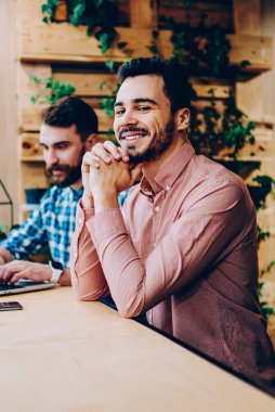 Üniversite kampüsünde başarılı freelancer online başlamak ile arkadaşı ile memnun dizüstü bilgisayarda ödev erkek arkadaşıyla oturan kamera bakarak gülümseyen yakışıklı hipster adam portresi