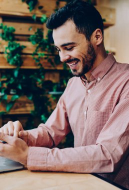 Neşeli hipster adam komik video gülüyor Smartphone'da serbest zaman sırasında genç erkek müreffeh freelancer telefon online kazanç para hareket bildirim almak ile memnun izledim