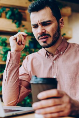 Uzaktan, kızgın genç erkek dizüstü ve üzgün faturaları internet bağlantısı kullanmak için almak posta kontrol çalışma netbook üzerinde dosyaları karşıdan yüklerken hipster adam yazılım hataları ile rahatsız vurguladı