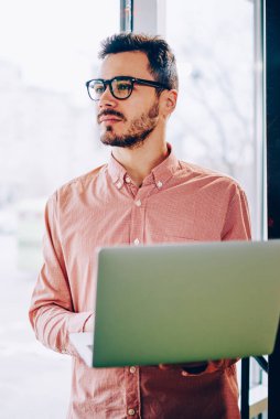 Profesyonel erkek bu gözlükler uzak tutarak dizüstü arıyorum geliştirici bilgisayar, netbook ağ abd bilgi aramak için kullanarak gelecekteki proje fikri aklından dalgın hipster adam