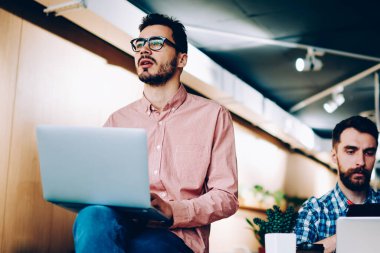 Birlikte oturma içinde yazıhane yaratıcı çözümler yapma projesi tamamlamak için yetenekli erkek programcılar bilgi analiz modern dizüstü bilgisayarlar çalışan genç erkekler ağlarda göz.