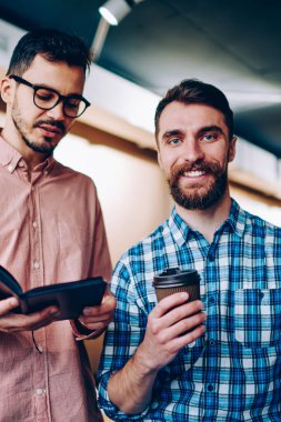 Erkek arkadaşınızın arkadaşıyla ile işbirliği zevk kamera bakarak gülen Defteri'nden, bilgi okuma meslektaşım ile kahve Kupası ayakta adamla neşeli sakallı hippi portresi