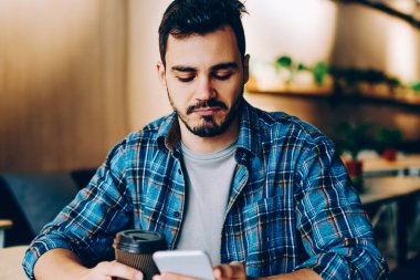 Dalgın genç adam dostları Güncellenme Zamanı kontrol n sosyal ağlar üzerinden cep kahve molası sırasında tarama hipster adam video online eğlence sırasında izlemek için telefon üzerinde düşünme profilleri