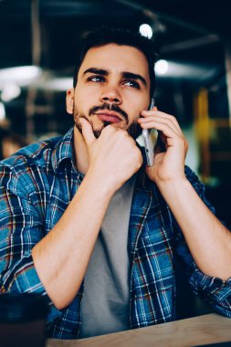 Düşünceli hippi adam, kafede arkadaşlarıyla telefonda konuşurken, cep telefonundan müşteri destek hattıyla bağlantı kurmayı bekleyen düşünceli bir genç adamla buluşmayı düşünüyor.