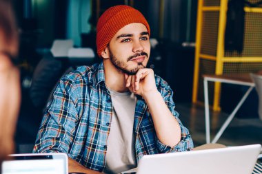 Hayalperest hippi adam çalışma sürecinden uzaklaştırıcı bir şey hayal et. Ofis programcılığında iş arkadaşıyla otururken tatilde olduğunu düşünen düşünceli, olumlu bir adamın görüntüsü.