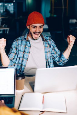 Dizüstü bilgisayarda çalışan erkek çalışanın arka planda ekranı taklit ederken, elleri havada olan duygusal meslektaşı zafer çığlıkları atıyordu. Hipster adam futbol maçı çevirisine hayran kalmıştı.