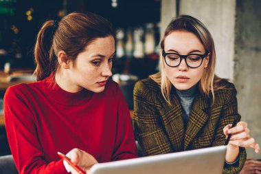 Ayrıntılar teamworking modern dizüstü bilgisayar, tartışırken iki profesyonel grafik tasarımcıları. Yetenekli öğrenciler Webinar online yolu ile 4 g netbook üzerinde izlerken internet ve fikirler işbirliği sırasında analiz
