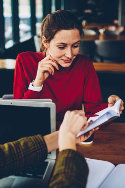 Dalgın güzel öğrenci kitap hangi kablosuz Internet bağlantısı eğitim alanı coworking ile modern netbooks, sınava hazırlık sırasında arkadaş tarafından gösterilen metin bilgileri okuma