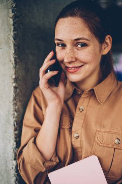 İstek-e doğru Smartphone cep telefonu ile arkadaş süre kamera gülümseyen pozitif genç kadın yarım uzunluk portre. Telefonda konuşmayı şirin neşeli öğrenci. Cep üzerinde konuşmak mutlu hippi kız