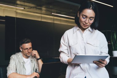 Milenyum Asyalı kadın optik gözlüklerle modern dokunmatik tablet teknolojisini kullanarak görüş düzeltmesi sağlıyor, kadın çalışan arama sitesi dijital tablet uygulaması üzerinden