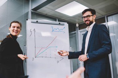 Akıllı Yardımcısı veren sunum toplantı, insanlar neden harika bir fikir gösteren flip grafik grafikler üzerinde yararları açıklayan yeni ofis hakkında konuşurken meslektaşları ile güzel iş kadını