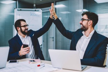 Erkek tasarımcılar ilk proje hazırlandı ve her diğer beş yüksek veren işadamı ile onların yeni ofisinde oturan toplantı üzerinde anlaşma memnun ve mutlu hissediyorum birlikte, başarı hakkında heyecanlı