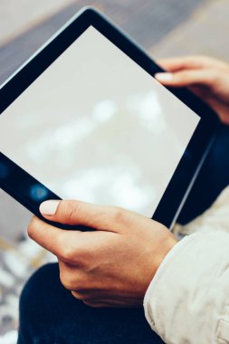 Boş ekran alanı için internet sitesi kadının elinde ile modern dokunmatik yüzey görünümünü kırpılmış. Hippi kız dijital tablet ile kopya alanı göstermek için açık havada oturma reklam holding