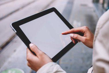 Kadının kırpılmış görünümünü internet reklam için modern Dokunmatik ped cihaz boş ekran alanı ile tutarak veya Web sitesi içeriği eller. Kadın kişi parmak görüntülenme hızını sahte tablete dokunmadan