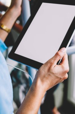 Tablet ayakta tramvay ve aygıtınızda yüklü audi uygulamadan müzik dinleme ile kadının el görünümünü kapatın. Modern tutan kadın kişi dokunmatik ekranla paneliyle Internet iletisi için