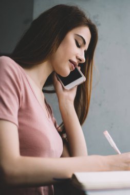 Akıllı telefondan konuşan ve kafeteryadaki dizüstü bilgisayar başında not alan konsantre ve çalışkan bir bayanın bakış açısından.