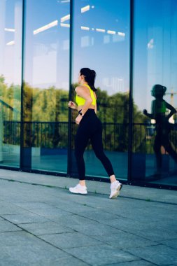 Şehir merkezinde kardiyo eğitimi alan atletik yapılı kadın vücut geliştirici, şehirde dayanıklılık egzersizi yapmaktan hoşlanan kaslı bir kadın aktif sporla sağlıklı yaşam tarzı uyguluyor.