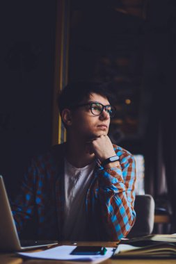 Düşünceli yaratıcı tasarımcı, modern dizüstü bilgisayarın başında oturan ve kablosuz internete bağlanan dul kadına bakıyor. Gözlükçü dükkanında çalışan düşünceli bir bilişim uzmanı.