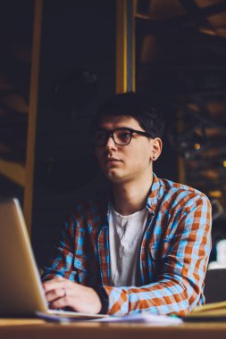 Macbook bilgisayarının başında oturan düşünceli blogcu kendi web sitesini kurmak için ilginç fikirler düşünüyor. Dizüstü bilgisayarda okuyan ve yaklaşan sınavlara hazırlanan genç adam.